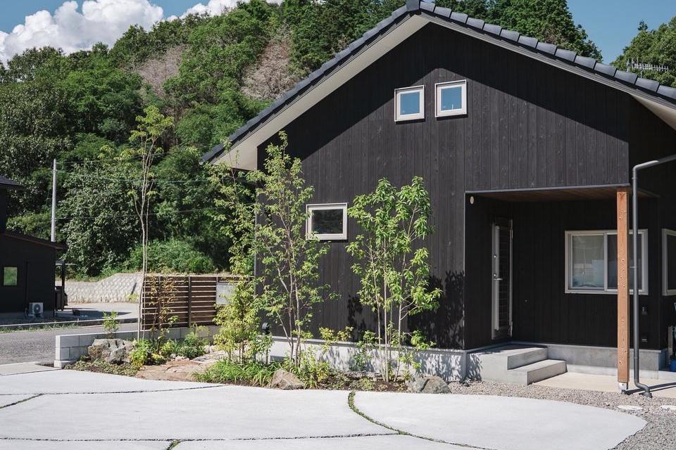 焼き板の家に寄り添う庭の画像